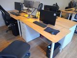 a desk with two computers and a chair in front of it