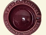 a close up of a red ashtray with writing on it