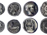 un gros plan sur un ensemble de pièces de monnaie anciennes posées sur une surface blanche