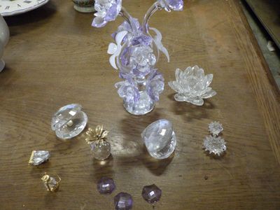 une table sur laquelle se trouvent un vase de fleurs et un ensemble de cristaux
