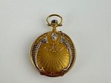 a close up of a gold locke with a diamond in the center