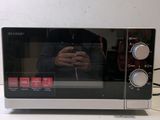 someone is taking a picture of a microwave with their reflection in the oven door