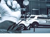 a hand holding a sign with a police car in the background