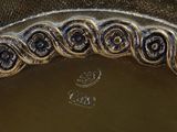 a silver plate with a decorative design on it