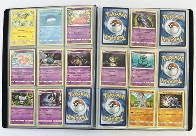 beaucoup de cartes Pokémon dans un album posé sur la table