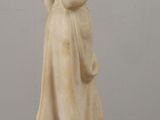 a statue of a woman holding a book on a table
