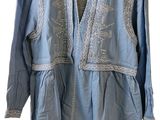 chemise bleue à manches longues, avec une broderie blanche sur la poitrine