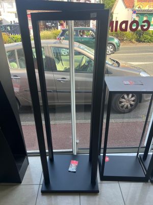 un parcmètre devant une fenêtre, avec une voiture en arrière-plan