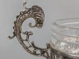 a silver teapot with a handle on a table