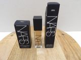 trois produits de beauté Nars posés sur une table en bois