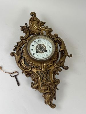 une horloge accrochée au mur, à laquelle est attachée une clé
