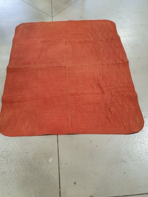 an orange rug sitting on the floor in a kitchen next to a sink