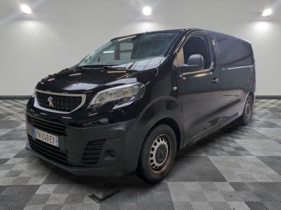 La camionnette noire est garée sur un sol carrelé à damier.
