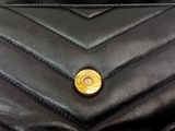 a black purse that has a gold button on it
