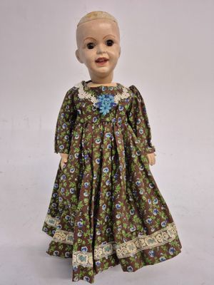 an image of a doll that is wearing a dress with flowers on it