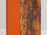 a book with orange cover sitting on top of a white table