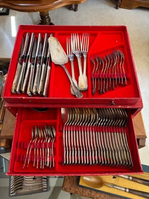 beaucoup d'argenterie dans une boîte rouge posée sur une table