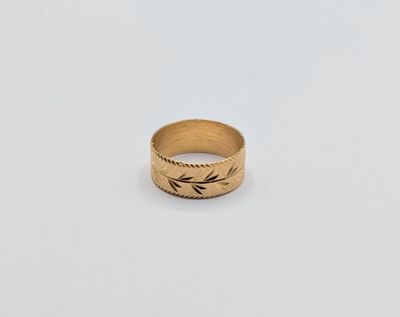gros plan d'une bague en or sur une surface blanche
