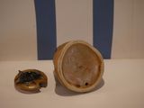 a small figurine sitting next to a smaller figurine on a table