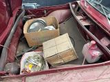 a red truck with a box of cooking utensils in the trunk