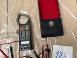 a box with a clamp, a meter, and wires on it