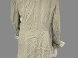 the back view of a mannequin wearing a beige jacket and black pants