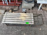 a wooden bench with a green sticker on it