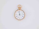 a gold pocket watch with a white face on a white surface