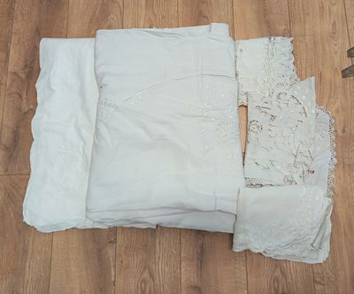 un tas de draps blancs et un sous-vêtement posés sur un plancher en bois
