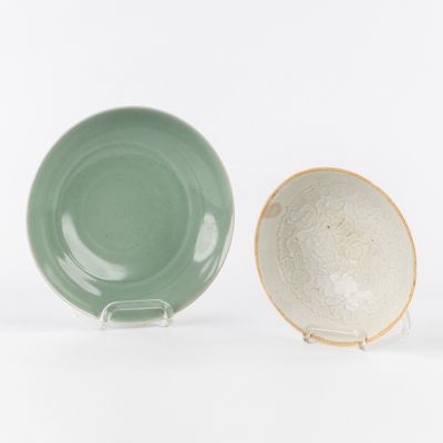 two green and white plates sitting next to each other on a white surface