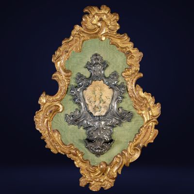 an ornate gold and green frame with a shield on top of it
