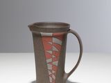 une tasse marron et rouge posée sur une table blanche, sur fond gris