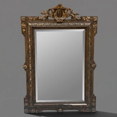 un miroir orné d'un cadre doré, surmonté d'une couronne