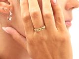 une femme qui porte une bague au doigt et une boucle d'oreille