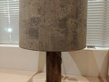 une lampe posée sur une table devant une fenêtre