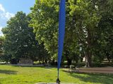 a blue sculpture in the middle of a grassy area