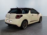 the rear end of a small white car parked in a room
