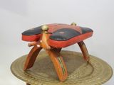 un tabouret en bois avec une assise rouge et noire