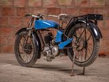 a blue motorcycle that is parked in front of a brick wall