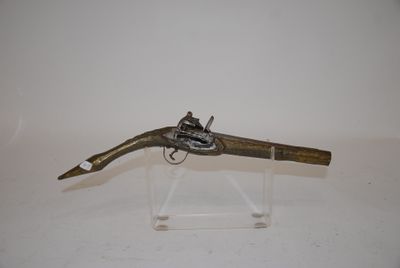 an old gun with a wooden handle on a clear stand