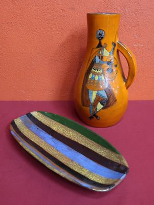 un vase et une assiette posés sur une table près d'un mur