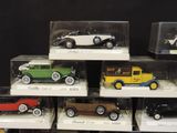 six different model cars are in a display case on a table