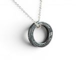 a close up of a necklace on a white surface with a chain