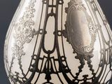 a silver vase with a black and white design on it