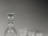 une carafe en verre et quatre verres à vin posés sur une table