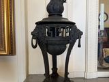 a large black vase with a horse head on top of it