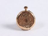 an image of a small gold pocket watch on a white surface