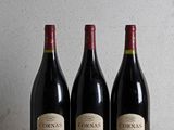 three bottles of wine are lined up on a wooden table