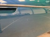 a close up of a car door handle with a reflection of a car in the background