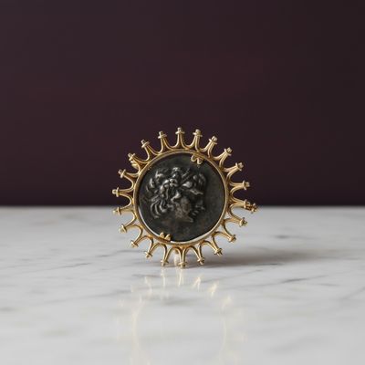 un gros plan d'une bague en or ornée d'un lion